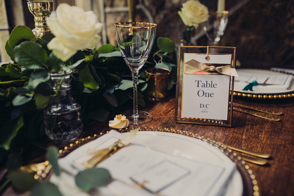 wedding checklist table number gold frame foliage flowers table plate glasses