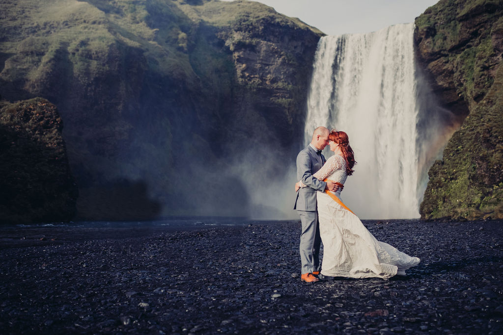 wedding checklist bride and groom embracing waterfall mountains behind