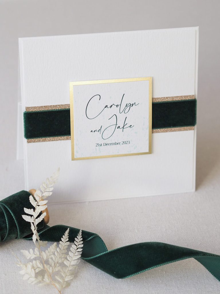 white pocketfold wedding invitation names and wedding date gold edge emerald green velvet ribbon gold glitter edge