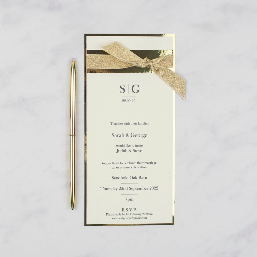flat ivory wedding invitation gold edge and gold sparkly ribbon gold pen